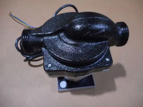 Pumpe von Remeha mit zwei Anschlussgewinden und drei elektrischen Leitungen, geeignet für verschiedene Heizungsanwendungen. Oberfläche in dunkler Farbe.